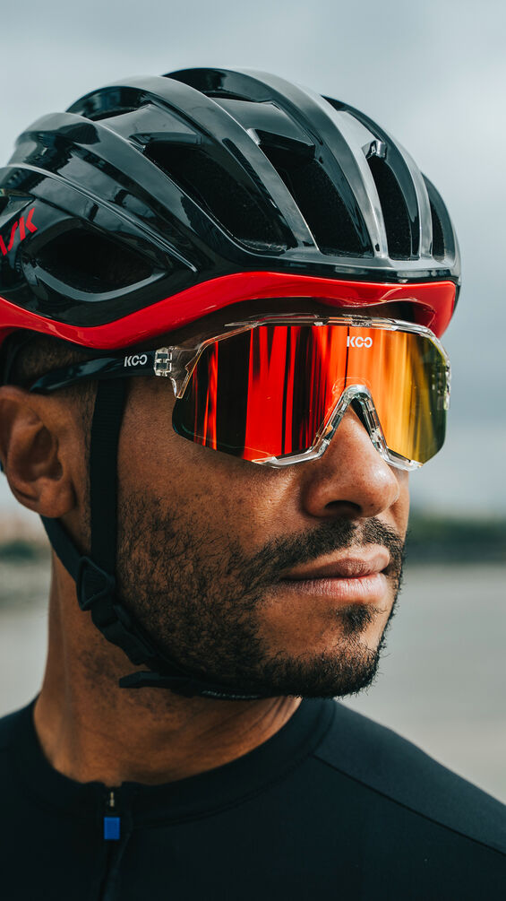 Koo Demos fietsbril met roodoranje spiegellens, gedragen onder een helm