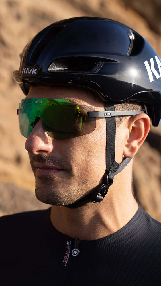 Koo Nova fietsbril met groene spiegellens onder een zwarte KASK helm