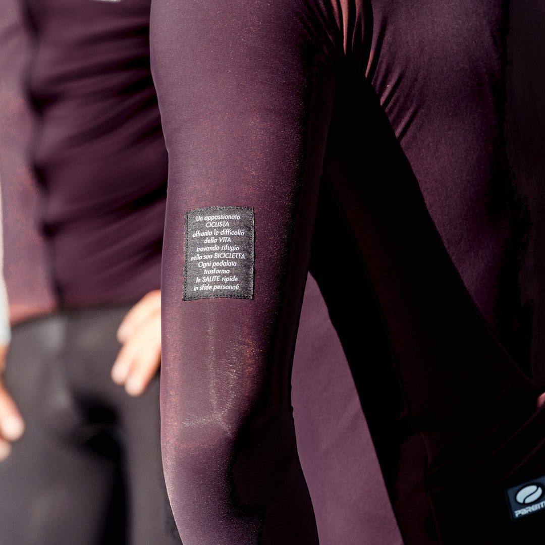 Parentini Unica Amarone — longsleeve fietsshirt gedragen, close-up van de mouw met geweven label