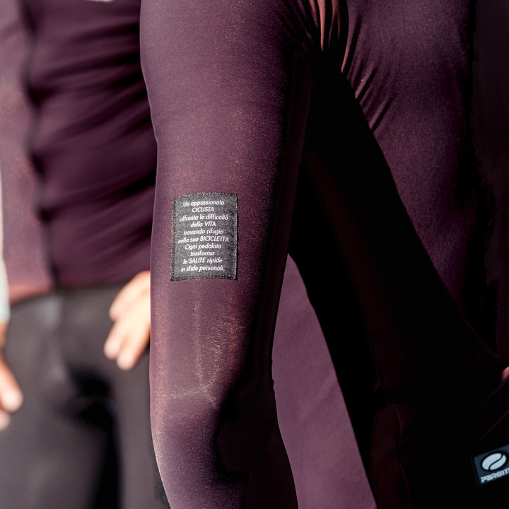Parentini Unica Amarone — longsleeve fietsshirt gedragen, close-up van de mouw met geweven label