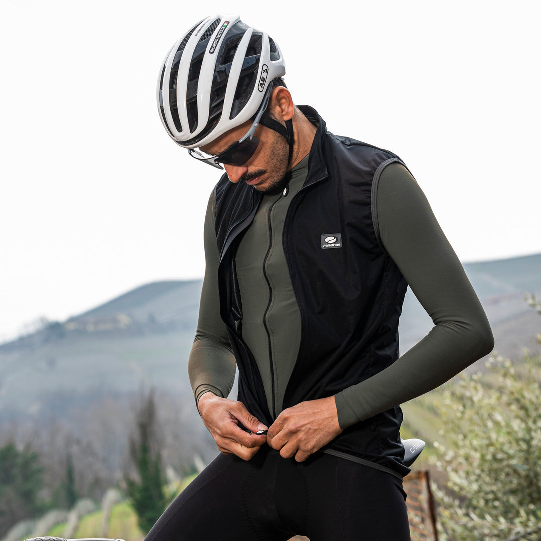 Parentini Unica forest groen — longsleeve fietsshirt gedragen onder een zwarte bodywarmer, naast de fiets